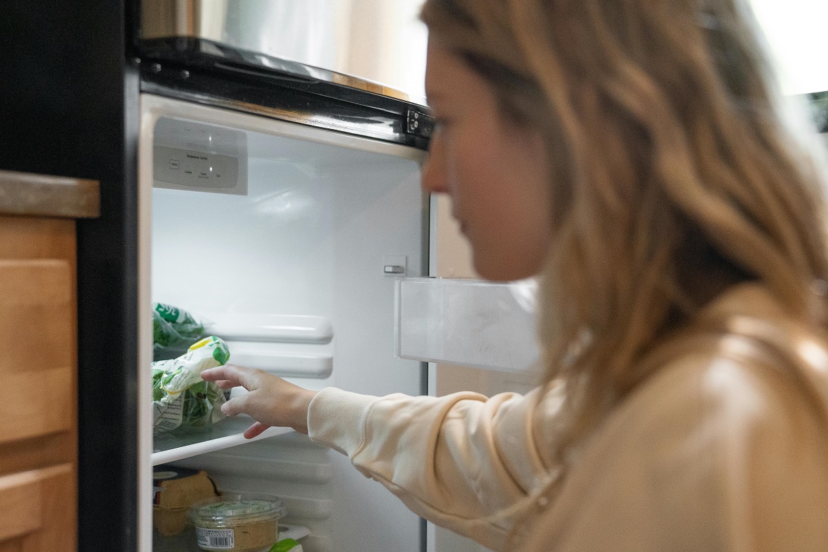 woman getting food from a refrigerator
